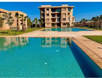 a large swimming pool in front of a building at Appartement de rêve à Marrakech in Marrakech