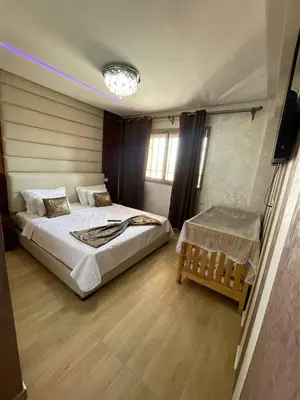 a bedroom with two beds and a television in it at Appartement de rêve à Marrakech in Marrakech