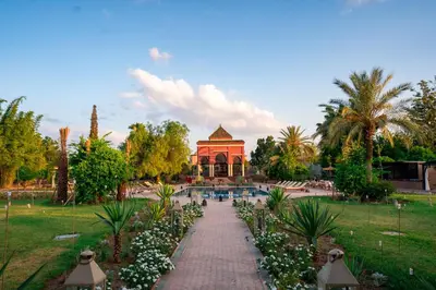 a garden with a building and a walkway with flowers at Nomadz Palace in Marrakech