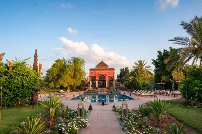 a swimming pool in a garden with a gazebo at Nomadz Palace in Marrakech