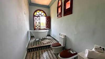 a bathroom with a toilet and a sink and a window at Nomadz Palace in Marrakech