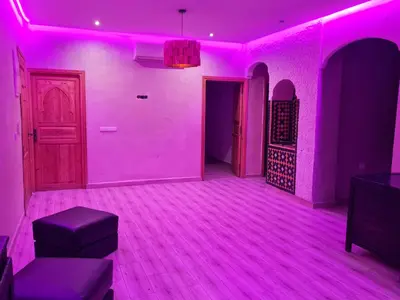 a purple room with a door and a couch and stool at Hostel Ghali & Private Rooms Gueliz in Marrakech