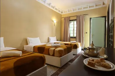 a hotel room with three beds and a table at HOTEL CTM in Marrakech