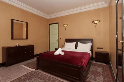 a bedroom with a large bed and a mirror at HOTEL CTM in Marrakech