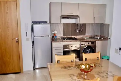 a kitchen with a refrigerator and a table with chairs at Studio cosy au centre de Marrakech in Marrakech