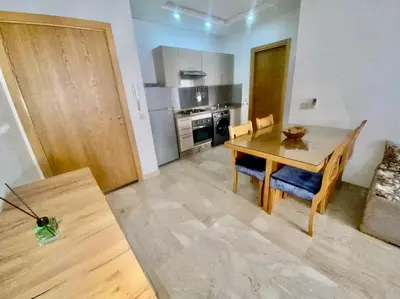 a kitchen with a wooden table and a dining room at Studio cosy au centre de Marrakech in Marrakech