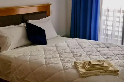 a white bed with a towel on it with a window at Studio cosy au centre de Marrakech in Marrakech