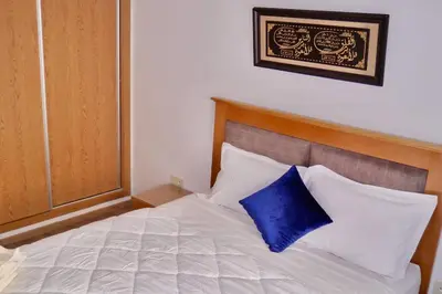 a bed with a blue pillow on top of it at Studio cosy au centre de Marrakech in Marrakech