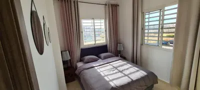 a small bedroom with a bed and two windows at Entre ville et détente- les portes de Guéliz in Marrakech