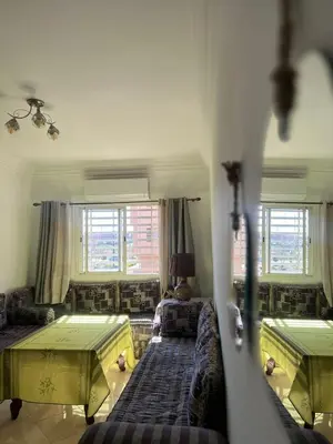 a living room with two beds and windows at Entre ville et détente- les portes de Guéliz in Marrakech