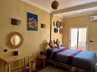a bedroom with a bed and a mirror and a table at Maison Mamdy Rooftop in Marrakech
