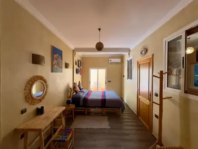a bedroom with a bed and a table and a mirror at Maison Mamdy Rooftop in Marrakech