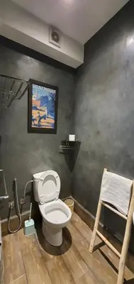 a bathroom with a toilet and a painting on the wall at Maison Mamdy Rooftop in Marrakech