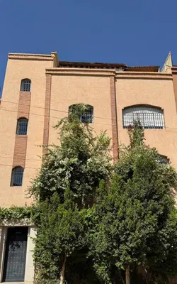 a tall building with a tree in front of it at Maison Mamdy Rooftop in Marrakech