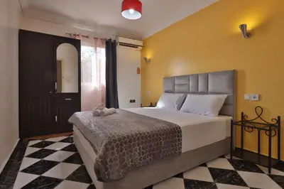 a bedroom with a large bed in a room at Résidence Assiyahia avec piscine Marrakech in Marrakech