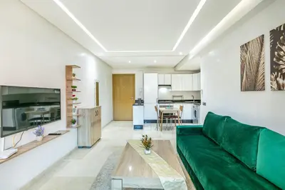 a living room with a green couch and a table at Élégant Appartement , Terrasse in Marrakech
