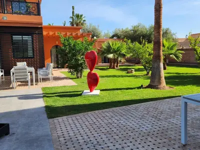 a red sculpture sitting in the middle of a park at Domaine K Marrakech in Marrakech