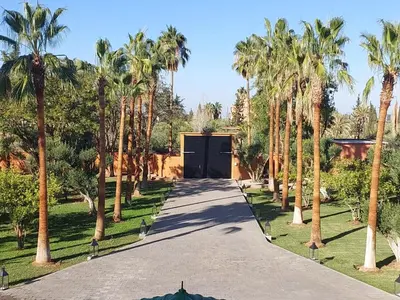 a driveway with palm trees in front of a garage at Domaine K Marrakech in Marrakech