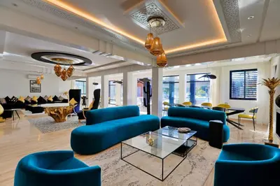 a living room with blue couches and chairs at Domaine K Marrakech in Marrakech
