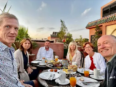 a group of people sitting around a table eating at Riad Atrium & Spa in Marrakech