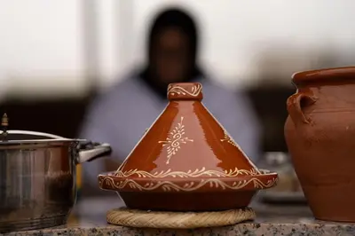 a clay pot sitting on a table with a person in the background at Riad Atrium & Spa in Marrakech