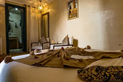 a large bed with a dress on it in a bedroom at Riad Atrium & Spa in Marrakech