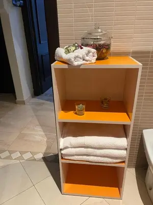 a shelf in a bathroom with towels and a fish bowl at Magnifique Appartement spacieux confort propre familial 2 chambres salon et salle a manger a 20mn a pied de place jemaa el fina 4 piscines dans espace de Golf a 12 mn en voitures l entree est gratuit pour la clientele ouvert entre 10h et 20h in Marrakech