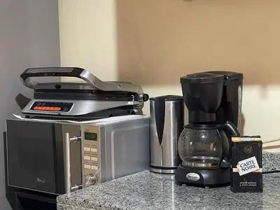 a coffee maker sitting on top of a coffeemaker at Magnifique Appartement spacieux confort propre familial 2 chambres salon et salle a manger a 20mn a pied de place jemaa el fina 4 piscines dans espace de Golf a 12 mn en voitures l entree est gratuit pour la clientele ouvert entre 10h et 20h in Marrakech