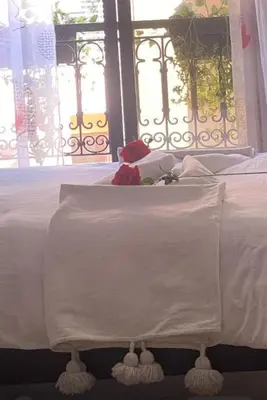 a white bed with white sheets and a window at Magnifique Appartement spacieux confort propre familial 2 chambres salon et salle a manger a 20mn a pied de place jemaa el fina 4 piscines dans espace de Golf a 12 mn en voitures l entree est gratuit pour la clientele ouvert entre 10h et 20h in Marrakech