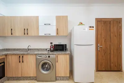 a kitchen with a refrigerator and a washing machine at appartement piscine proche gare in Marrakech