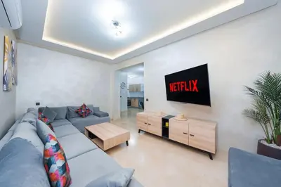 a living room with a couch and a tv at appartement piscine proche gare in Marrakech