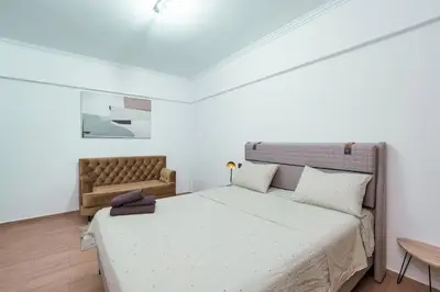 a bedroom with a large bed and a chair at appartement piscine proche gare in Marrakech