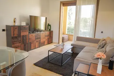 a living room with a couch and a tv at Havre de Paix Piscine Lagon & parc in Marrakech