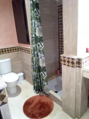 a bathroom with a toilet and a shower with a rug at Luxury apartment 3 in the heart of Gueliz, Wifi, Pool in Marrakech