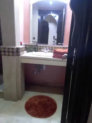 a bathroom with a sink and a mirror and a rug at Luxury apartment 3 in the heart of Gueliz, Wifi, Pool in Marrakech