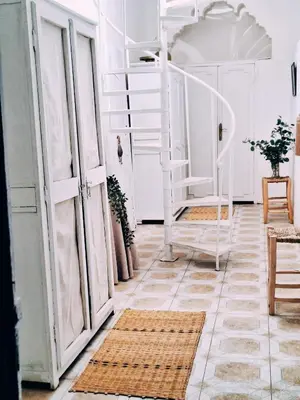 a room with white doors and a floor with rugs at STUDIO BLANCO MÉDINA AVEC TERRASSE in Marrakech