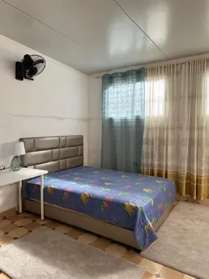 a bedroom with a bed and a desk and a window at Gueliz Center Home (Starbucks) in Marrakech
