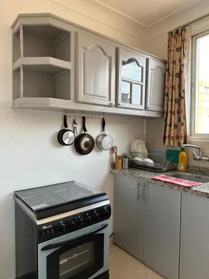 a kitchen with white cabinets and a stove top oven at Gueliz Center Home (Starbucks) in Marrakech