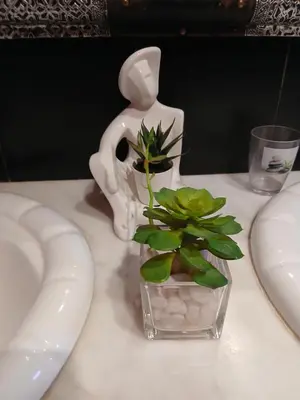 a white vase with a plant in it on a table at Paradise house in Marrakech