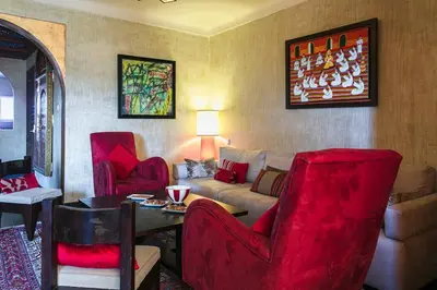a living room with red chairs and a couch at Gueliz Gala – Marrakech Centre in Marrakech