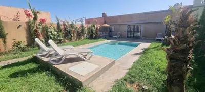 a swimming pool with two lounge chairs in a yard at city garden Kech in Marrakech
