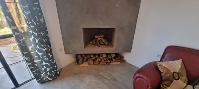 a room with a fireplace with a pile of logs at city garden Kech in Marrakech