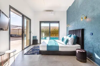 a bedroom with a king sized bed and a patio at Villa Dalia, Personnels et option piscine in Marrakech