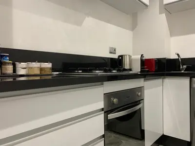 a kitchen with white cabinets and a black counter top at Rooftop Pool, Atlas View, M avenue in Marrakech