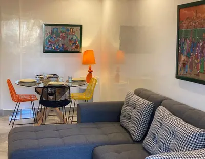 a living room with a couch and a table with chairs at Rooftop Pool, Atlas View, M avenue in Marrakech