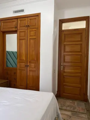 a bedroom with a bed and a wooden door at Au cœur de la palmeraie de Marrakech in Marrakech