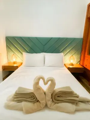 two swans are forming a heart on a bed at Au cœur de la palmeraie de Marrakech in Marrakech