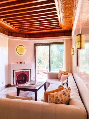 a living room with a couch and a fireplace at Au cœur de la palmeraie de Marrakech in Marrakech