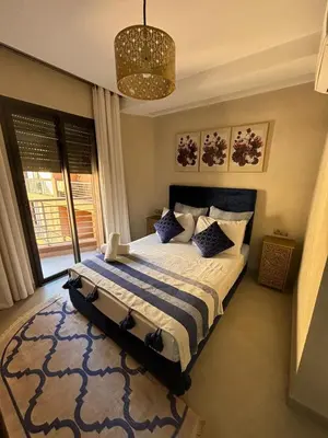a bedroom with a bed and a chandelier at Appartement neuf climatisé, centre Marrakech. in Marrakech