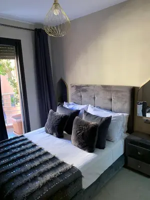 a bedroom with a large bed with black and white pillows at Appartement neuf climatisé, centre Marrakech. in Marrakech